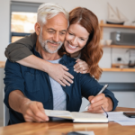 woman hugging man from behind while he goes over succession planning
