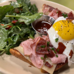 A breakfast plate from Snooze, an A.M. Eatery featuring eggs, ham and a side salad.