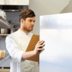 Man staring into fridge at a restaurant.