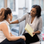 Woman comforting another woman, creating open dialogue within the team.